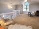 Spacious loft area with neutral carpet, desk setup, and a large arched window at 8212 Borgia Ct, Orlando, FL 32836
