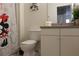 Bathroom with white cabinets, toilet, sink, mirror and a Disney themed shower curtain at 151 Pompano Beach Dr, Kissimmee, FL 34746