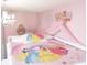Enchanting pink princess-themed bedroom with chandelier, crown decor, and character bedding at 151 Pompano Beach Dr, Kissimmee, FL 34746