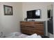 Bedroom features a dresser, mirror, and mounted TV, creating a relaxing and functional space at 151 Pompano Beach Dr, Kissimmee, FL 34746