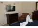 Comfortable bedroom featuring a queen bed, television, sitting area, and dresser at 151 Pompano Beach Dr, Kissimmee, FL 34746