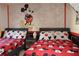 Themed bedroom with two beds, Mickey Mouse bedding, and a playful wall mural for a fun retreat at 151 Pompano Beach Dr, Kissimmee, FL 34746
