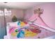 Enchanting pink princess-themed bedroom with chandelier, crown decor, and character bedding at 151 Pompano Beach Dr, Kissimmee, FL 34746