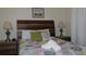 Comfortable bedroom featuring a stylish wooden headboard, bedside lamps, and colorful patterned bedding at 151 Pompano Beach Dr, Kissimmee, FL 34746