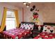 Whimsical bedroom featuring Mickey Mouse decor, playful bedding, and comfortable sleeping arrangements at 151 Pompano Beach Dr, Kissimmee, FL 34746