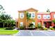 Charming townhome with a terracotta tile roof, lush landscaping, and an assigned parking spot for convenient access at 151 Pompano Beach Dr, Kissimmee, FL 34746