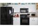 Modern kitchen features white cabinets and updated black appliances at 151 Pompano Beach Dr, Kissimmee, FL 34746