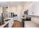 Bright open kitchen with white cabinets, stainless steel appliances and stone countertops at 1034 Foreshore Ln, Haines City, FL 33844