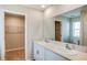 Bathroom featuring double sinks with a quartz countertop and a large mirror, next to a walk in closet at 4047 Gardenia Ave, Lake Hamilton, FL 33851