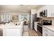 Modern kitchen features white cabinets, stainless steel appliances, large island, and an eat in dining area at 4047 Gardenia Ave, Lake Hamilton, FL 33851