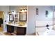 Bathroom featuring double sinks with gold basin bowls and dark cabinetry at 210 Cheshire Way, Davenport, FL 33897