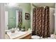 Bathroom featuring a decorative shower curtain and vanity with a large mirror at 210 Cheshire Way, Davenport, FL 33897