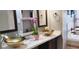 Bathroom with double sinks, gold basin bowls, marble countertop, and dark cabinets at 210 Cheshire Way, Davenport, FL 33897