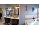 Bathroom featuring double sinks with gold basin bowls and dark cabinetry at 210 Cheshire Way, Davenport, FL 33897