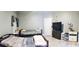 Bedroom with two beds, light grey walls, and wood-look laminate flooring at 210 Cheshire Way, Davenport, FL 33897