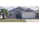 Charming single-story home featuring a well-manicured lawn and a two-car garage at 210 Cheshire Way, Davenport, FL 33897