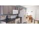 Bright kitchen featuring stone backsplash, countertop, stainless appliances, breakfast nook, and tile floor at 210 Cheshire Way, Davenport, FL 33897