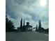 View of the community entrance with fountain and palm trees on a partly cloudy day at 3205 Sonesta Ct # B, Clermont, FL 34711