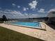 Community pool with chairs overlooking a lake at 1550 11Th Ne St # G8, Winter Haven, FL 33881