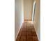 Narrow hallway featuring neutral paint and tile floors leading towards a doorway at 1550 11Th Ne St # G8, Winter Haven, FL 33881