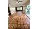 Bright living room featuring neutral paint, tile floors, a window, and sliding glass door to a balcony at 1550 11Th Ne St # G8, Winter Haven, FL 33881