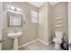 Contemporary half bathroom with pedestal sink, toilet, and modern fixtures, ideal for guests at 2448 Brownwood Dr, Mulberry, FL 33860