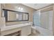 Large primary bathroom with custom vanity, decorative mirror, and a shower/tub combo at 2448 Brownwood Dr, Mulberry, FL 33860