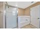 Bright bathroom with a shower, a white tub with white tile and tan walls at 2448 Brownwood Dr, Mulberry, FL 33860