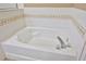 Close up on a clean white bathtub with tan and white backsplash at 2448 Brownwood Dr, Mulberry, FL 33860