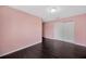 A bedroom features hardwood floors, light pink walls, and a white closet at 2448 Brownwood Dr, Mulberry, FL 33860