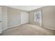 A simple carpeted bedroom with a window and a closet with white doors at 2448 Brownwood Dr, Mulberry, FL 33860