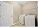 A laundry room with a white washer and dryer on a tiled floor at 2448 Brownwood Dr, Mulberry, FL 33860