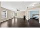Bright living room featuring wood floors, neutral walls, and views to an adjacent bedroom through an open doorway at 2448 Brownwood Dr, Mulberry, FL 33860