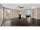 Spacious living area with wood floors, ceiling fan, and ample natural light from large windows at 2448 Brownwood Dr, Mulberry, FL 33860