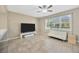 Open space featuring a ceiling fan, tiled floors, a white sofa, and a large window with blinds at 2448 Brownwood Dr, Mulberry, FL 33860