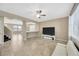 Bright open space with tiled floors, a ceiling fan, a white sofa, and a television at 2448 Brownwood Dr, Mulberry, FL 33860