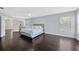 Spacious main bedroom with dark wood floors and a king bed adjacent to a walk-in closet and the main bathroom at 2448 Brownwood Dr, Mulberry, FL 33860