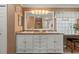 Bathroom with a vanity featuring double sinks, granite counter tops, seating, a large mirror and custom lighting at 2522 Pine Valley Dr, Lakeland, FL 33810