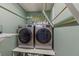 Convenient laundry room with modern washer and dryer and built-in storage and folding rack at 2522 Pine Valley Dr, Lakeland, FL 33810