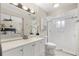 Bright bathroom with a white vanity, framed mirror, and a walk-in shower with glass door at 100 Essex Dr, Longwood, FL 32779
