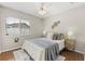 Cozy bedroom featuring a ceiling fan, stylish decor, and a window providing natural light at 100 Essex Dr, Longwood, FL 32779