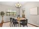 Well-lit dining room with a modern chandelier, table set for six, and large window at 100 Essex Dr, Longwood, FL 32779
