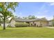 Charming single-story home with a well-maintained lawn, landscaping, and attached garage at 100 Essex Dr, Longwood, FL 32779