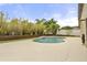Landscaped backyard with a private pool, mature plants, and a concrete pool deck at 100 Essex Dr, Longwood, FL 32779