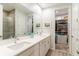 Bright bathroom featuring double vanity with white countertop, walk-in closet and modern wood-style floors at 7418 Barrier Cove Way, Celebration, FL 34747