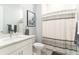 Bright bathroom with a single sink vanity, framed mirror, and a shower with a patterned curtain at 7418 Barrier Cove Way, Celebration, FL 34747