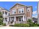 Charming two-story home with a welcoming front porch and manicured landscaping at 7418 Barrier Cove Way, Celebration, FL 34747