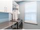 Well-equipped laundry room with modern washer, dryer, built-in cabinets, and a window at 7418 Barrier Cove Way, Celebration, FL 34747