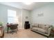 Comfortable living room with sofa, desk area, and wall decor creating a welcoming and functional space at 7418 Barrier Cove Way, Celebration, FL 34747
