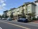 Commercial spaces and condos along a street lined with trees, offering a mix of living and shopping at 7418 Barrier Cove Way, Celebration, FL 34747